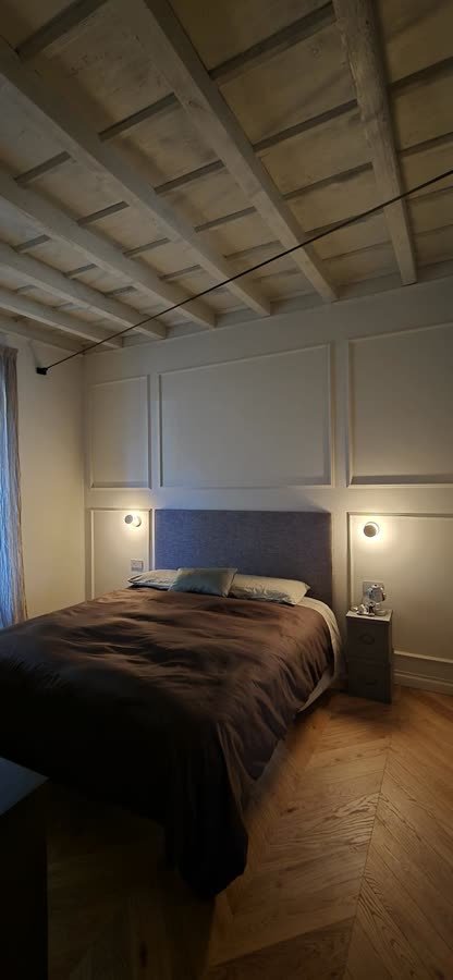 Camera con soffitto a travi e testiera imbottita