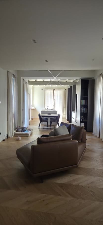 Enfilade verso il soggiorno con poltrona in pelle